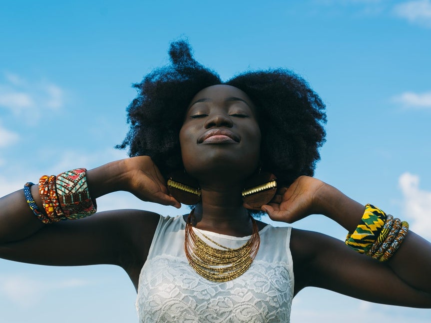 Portrait of a Black woman with blue sky behind her